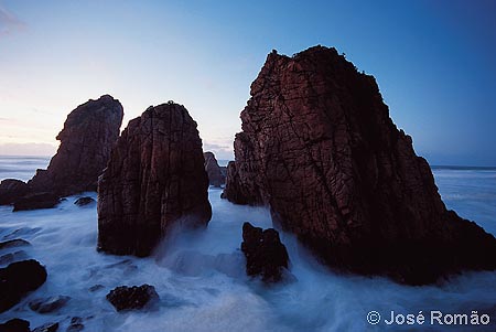 06188A Agitao do mar de Inverno por entre o granito rosa da Praia da Ursa. enevoado rochas emersas mar crepusculo Parque-Natural-Sintra-Cascais