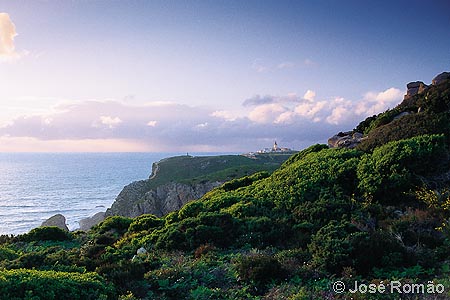 x06314B O Cabo da Roca - o ponto mais ocidental da Europa continental - e farol, vistos do Espinhao, a sul, ao fim da tarde. costa falsia mar arbustos verde Parque-Natural-Sintra-Cascais