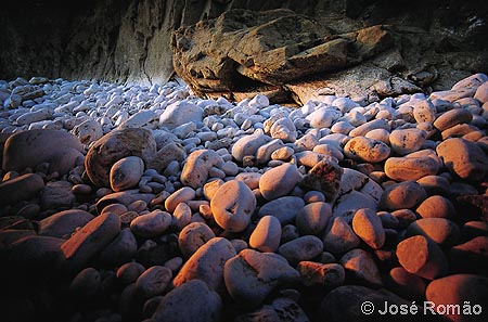 06110A Calhaus iluminados pela luz tangencial do pr-do-Sol no solstcio de Vero, Praia da Ursa. rochas pedras Parque-Natural-Sintra-Cascais